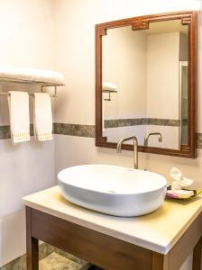 伯利兹城Golden Bay Belize Hotel的浴室设有白色水槽和镜子