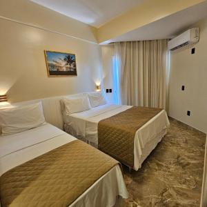 阿拉卡茹贾托巴海滩酒店的酒店客房设有两张床和窗户。
