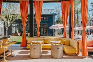 萨凡纳Hotel Bardo Savannah的庭院配有橙色窗帘、沙发和桌子