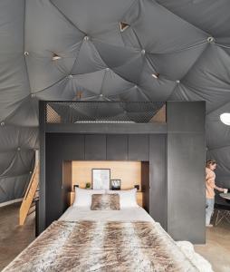 圣弗朗索瓦小河Dômes Charlevoix的一间卧室设有一张带灰色天花板的大床