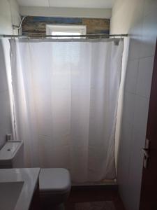 梅塞德斯La Demorada, cómoda casa en entorno natural的浴室配有白色的浴帘和卫生间