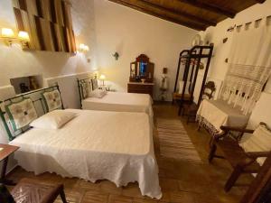 CurvatosSerra do Caldeirao Villa with Pool的一间卧室配有两张床和椅子