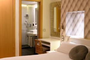 圣洛伦索-德埃斯科里亚尔德马丁酒店的一间卧室配有一张床,浴室设有淋浴。