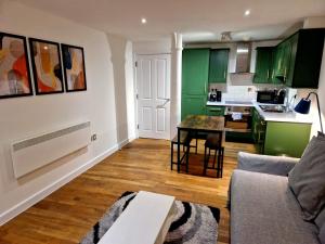 曼彻斯特Northern Quarter Flat的客厅配有绿色橱柜和桌子