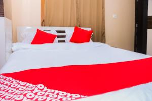 阿加尔塔拉OYO Hotel Sonar Gaon的红色和白色的床,上面有红色枕头