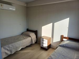 梅塞德斯La Demorada, cómoda casa en entorno natural的一间卧室设有两张床、一个梳妆台和窗户。