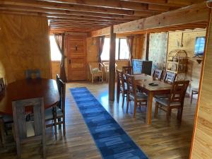 锡斯内斯港Hospedaje Alto Palena de Puerto Cisnes的小屋内带桌椅的用餐室