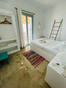 考弗尼西亚EOS - Appartement de charme et confort pour 4 personnes prés de la plage et du coeur de Koufonissi的一间白色卧室,配有床和地毯