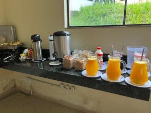 阿帕雷西达Hotel Vila dos Pescadores的盘子上放两杯橙汁的柜台