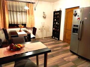 GhimbavMilu Residence 2的厨房以及带桌子和冰箱的用餐室