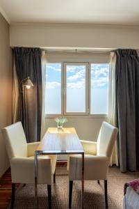 玛德琳港托洛萨酒店的一间带桌椅和窗户的用餐室