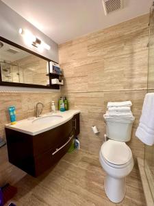 西湾Seven Mile View Condo 3A的一间带卫生间、水槽和镜子的浴室