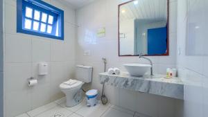 布希奥斯Pousada Vila Capri的白色的浴室设有水槽和卫生间。