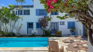 布希奥斯Pousada Vila Capri的一座带游泳池和房子的别墅