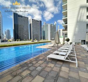 迪拜Reva residence suite burj Khalifa view ,Kings的一座游泳池旁设有躺椅和遮阳伞