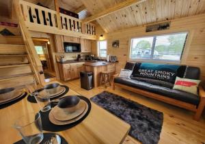 赛维尔维尔Picturesque Family Cabin with Loft in Tennessee的小屋内的客厅配有沙发和桌子
