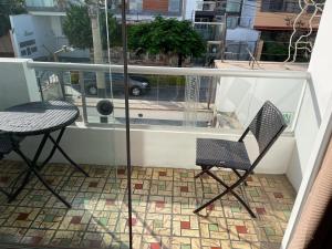 利马Lima HOUSE MILANI的阳台配有2把椅子和1张桌子