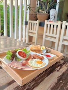 格兰岛BLUE OCEAN kohlarn resort的木桌上的早餐盘