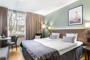 南泰利耶Best Western Plus Skogshöjd的配有一张床、一张书桌和一扇窗户的酒店客房