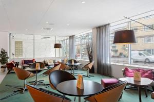 南泰利耶Best Western Plus Skogshöjd的餐厅设有桌椅和大窗户。