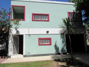 门多萨Encantador Departamento en Mendoza Domaine Laborde II的蓝色和白色的房子,设有红色窗户