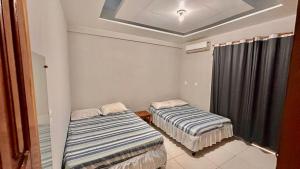特雷西纳Casa Piauí Hostel的带窗户的客房内的两张床