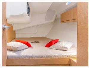 马赛VOILIER 12 Mtres 3 CABINES PROCHE JO MARSEILLE的小房间床上的2个红色枕头