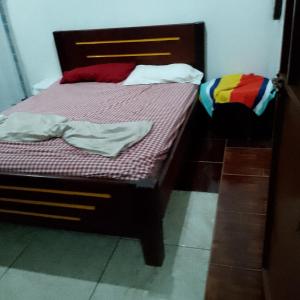 AltagraciaBeach cabin ometepe的一间卧室配有一张带紫色床单和丰富多彩枕头的床。