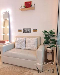 马尼拉La Casa Ysabela - Azure Affordable Staycation, Paranaque Metro Manila的客厅里的白色沙发,墙上有时钟