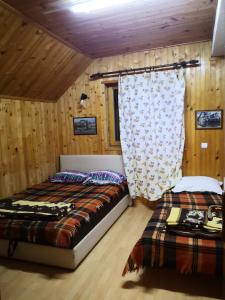 马夫罗沃Mountain Lodge - Mavrovo的配有木墙和木地板的客房中的两张床