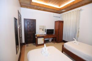 琅勃拉邦Villa KiengKham晶康民宿的客房设有两张床和一张带电脑的书桌