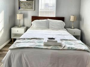 俄克拉何马城Spring Break Retreat Studio Rainfall Shower的一张带毯子的白色床和2个床头柜
