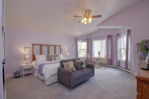 大章克申Castle Creek Manor的一间卧室配有一张床、一张沙发和吊扇。