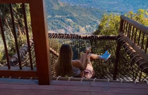 圣埃伦娜Skyline Ecoliving Santa Elena的坐在山景阳台上的女人