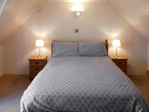 InveralliginSunnybank Cottage的一间卧室配有一张带两张台灯的床铺。