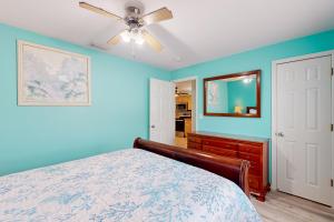 威尼斯Coastal Hideaway的蓝色卧室配有床和吊扇
