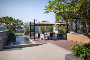 广州广州新世界酒店的一个带桌椅和遮阳伞的庭院
