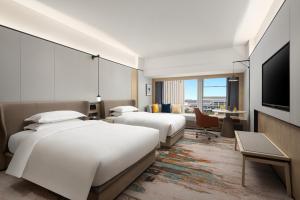 长沙voco 长沙机场voco酒店的酒店客房设有两张床和一台平面电视。