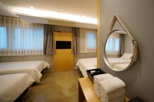 首尔Hotel DADA Insadong的酒店客房,设有两张床和镜子