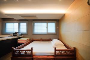 首尔Hotel DADA Insadong的一间设有床铺和两把椅子的房间