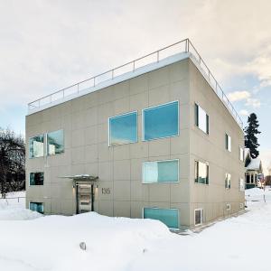 安克雷奇Snob Hollow Inn Downtown Anchorage的一座拥有蓝色窗户的雪地建筑