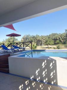 珀拉什奇亚The Tiki Toucan Tropical Suite + Private Pool的一个带两把椅子和遮阳伞的游泳池