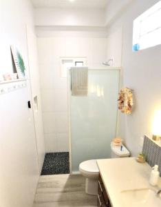 珀拉什奇亚The Tiki Toucan Tropical Suite + Private Pool的白色的浴室设有卫生间和水槽。