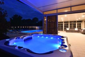 努尔卡巴HOT HOT Spoil someone special at this luxe Hunter Valley Estate - stunning luxury in super central location的房屋后院的按摩浴缸