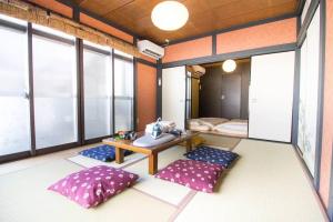 横滨SAMURAI HOUSE Yokohama的一间设有枕头、桌子和窗户的客房