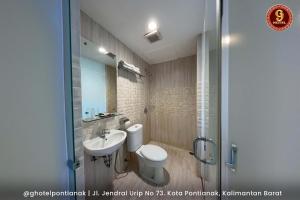 坤甸G坤甸酒店的浴室配有卫生间、盥洗盆和淋浴。