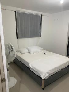 巴耶杜帕尔HOTEL IBIZA的一间卧室配有一张带风扇和窗户的床。