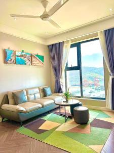 归仁ALTARA Quy Nhơn - RUBY Luxury Apartment的带沙发和大窗户的客厅