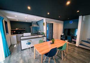大岛QUENOS的厨房以及带木桌和椅子的用餐室。