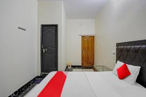 瓦拉纳西OYO Flagship J.d.p Guest House的卧室配有带红色枕头的大型白色床